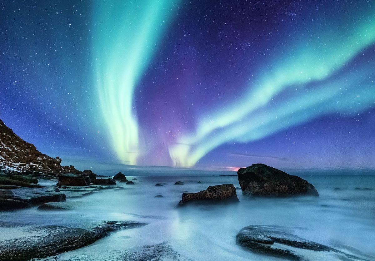 Aurora borealis on the Lofoten islands, Norway. Night sky with polar lights. Night winter landscape with aurora and reflection on the water surface. Natural background in the Norway
