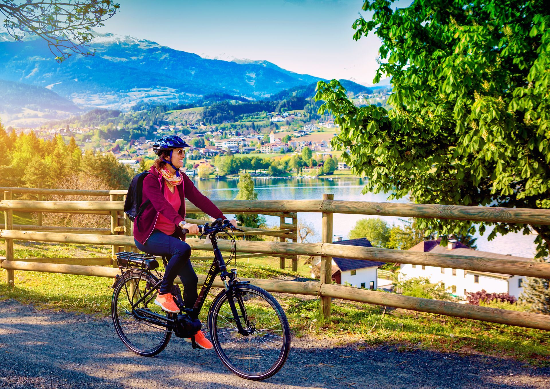 woman with e-bike cycling beside a beautiful lake-lake and bike