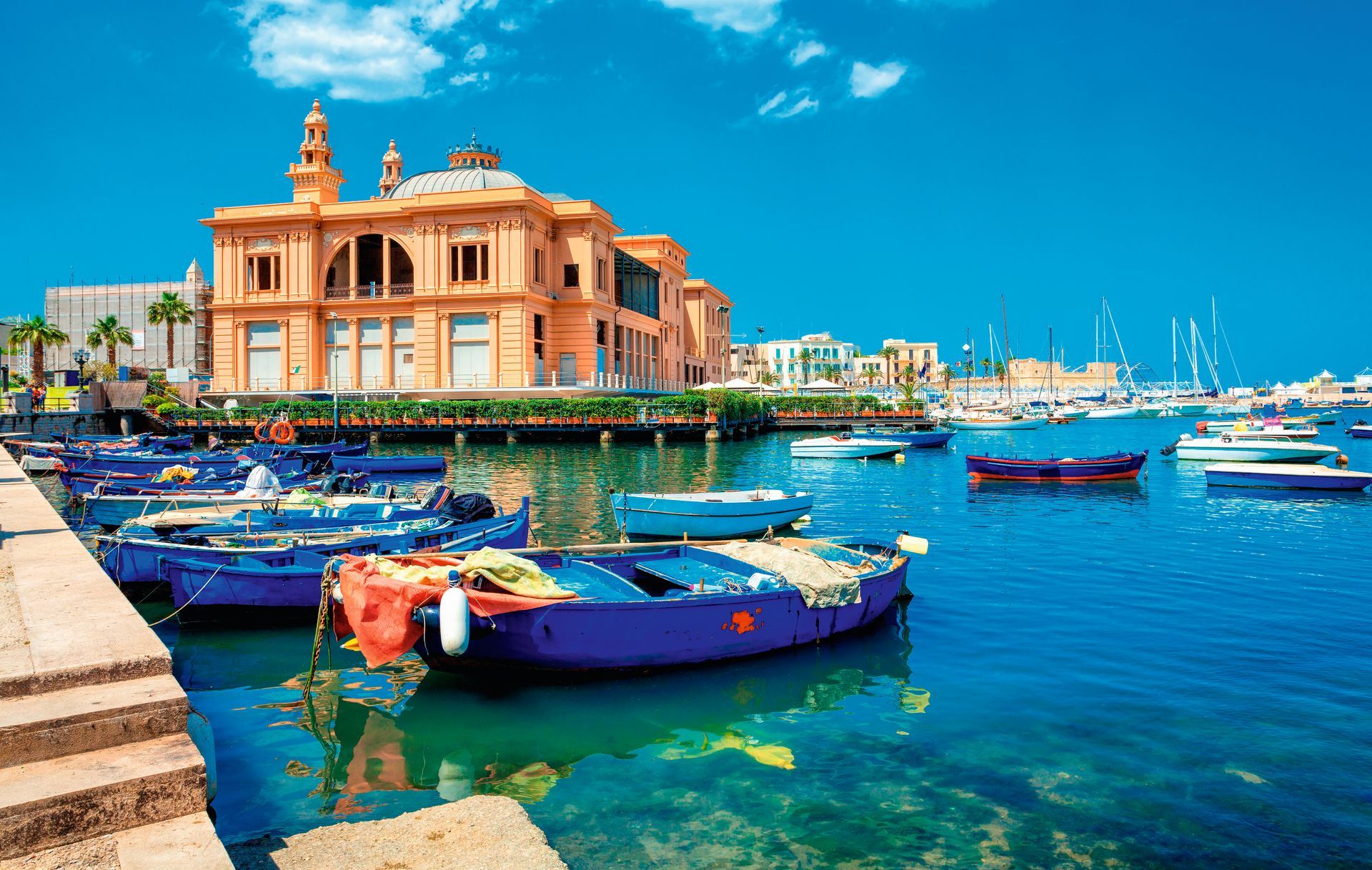 Margherita Theater and fishing row boat in old harbor of Bari, region of Apulia, Italy.